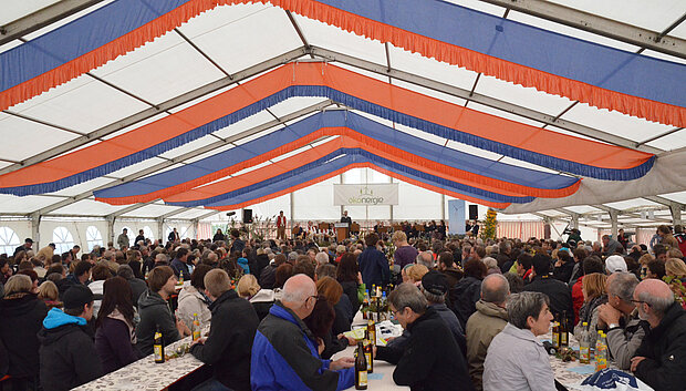 Feierlich geschmücktes Festzelt zur Einweihungsfeier des Bürgerwindparks Gollhofen-Rodheim – zahlreiche Gäste an langen Tischen, Bühne mit Rednerpult und Veranstaltungsbanner im Hintergrund.